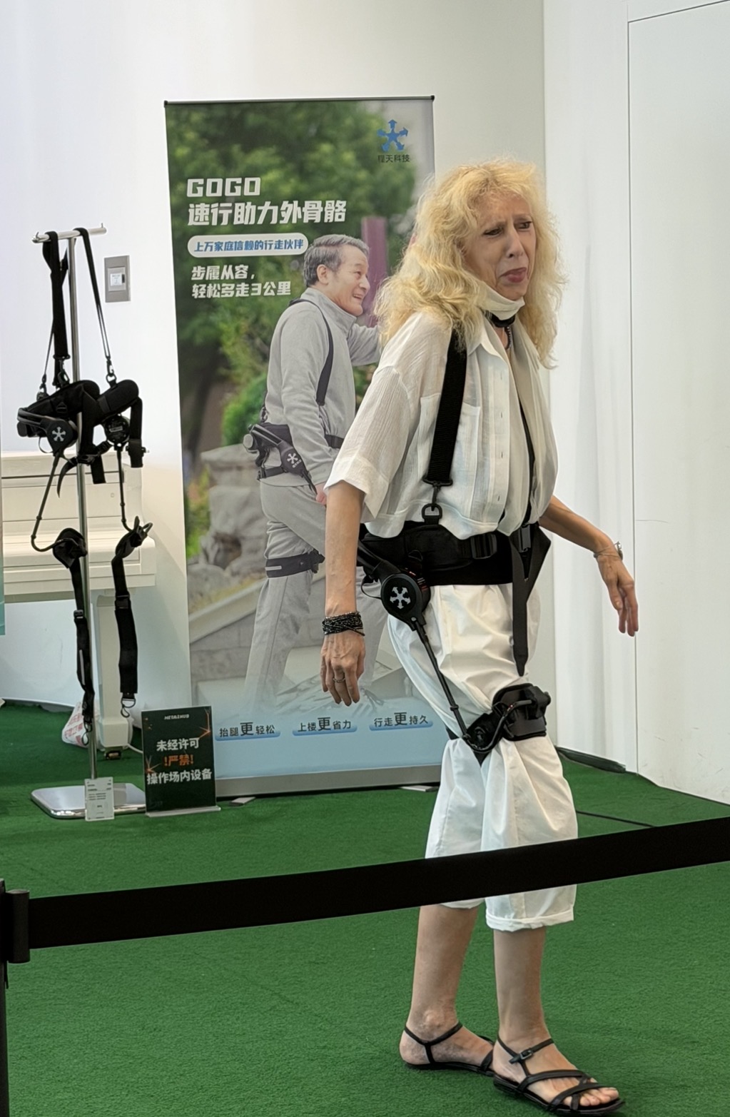 Bezoeker test een draagbaar exoskelet dat het lopen ondersteunt